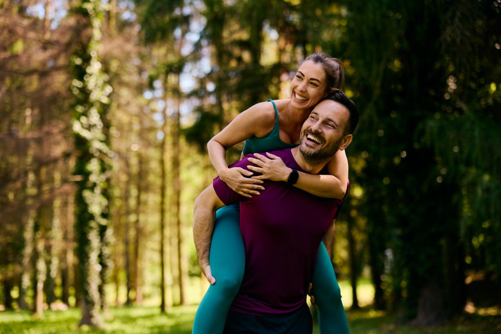 Happy couple exercising outdoors in woodland, representing healthy lifestyle and wellbeing