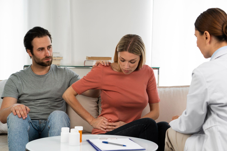 Patient discussing abdominal discomfort with a healthcare professional during a clinic appointment.