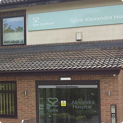 The clinic's entrance with brick walls, brown tiling above the door, brown windows, and a brown door.